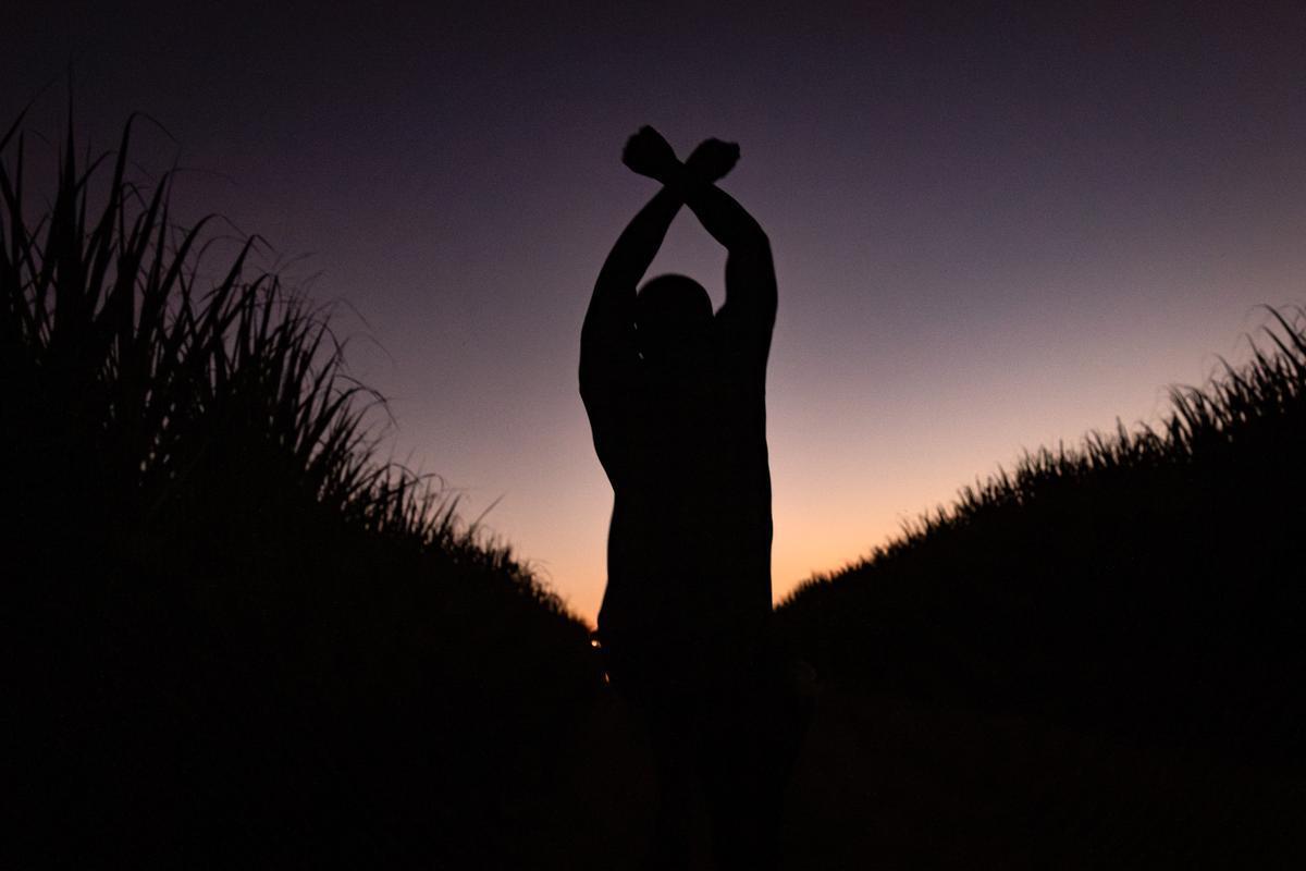 Batey Euskarduna, Repubblica Dominicana. dicembre 2024. Un ragazzo gioca saltando in una piantagione di canna da zucchero 