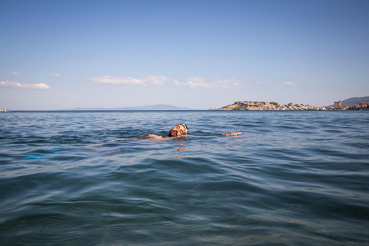 Lesbo (Grecia), estate 2024. Uno dei partecipanti al corso di nuoto di Yoga and Sport with Refugees si rilassa al largo dell'isola dopo una sessione di allenamento (Foto di Giacomo Sini)