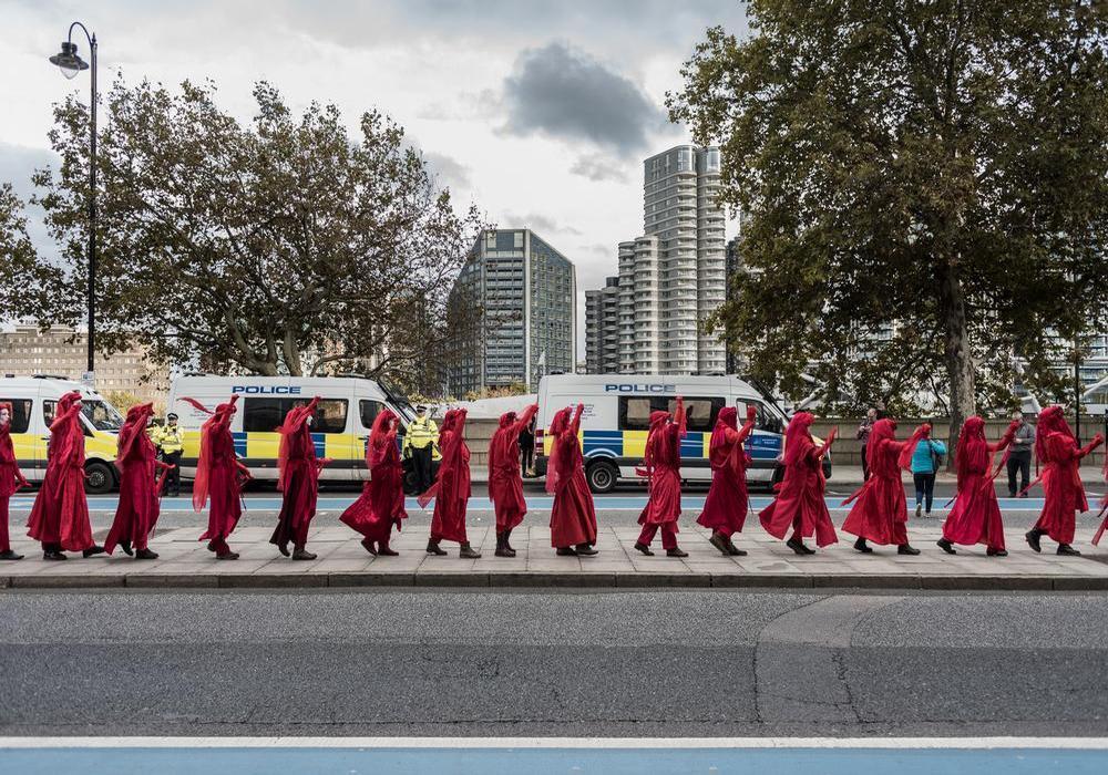 Londra, 15 ottobre 2019. The invisible circus durante l'azione davanti al MI5 HQ in Millbank. La Brigata rossa cammina silenziosamente in mezzo agli attivisti e attraversa il Millbank Pier (Foto Federico Tisa)