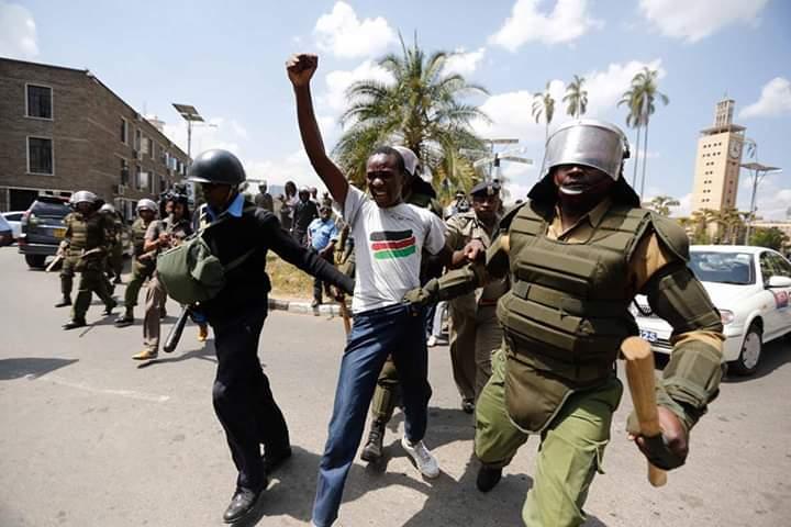 Francis Sakwa, attivista keniano, tra due agenti delle forze dell'ordine