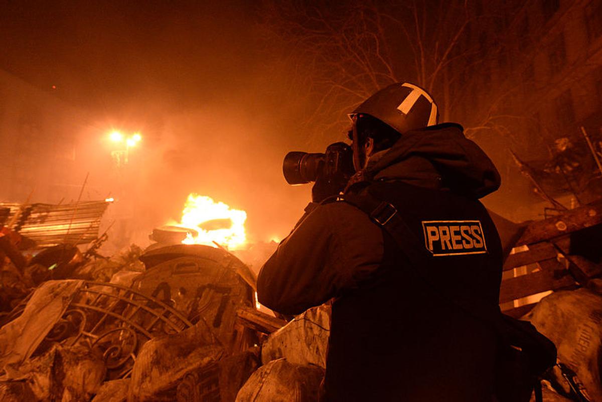 Un giornalista documenta gli scontri tra cittadini e polizia a Kyiv, nel 2014 