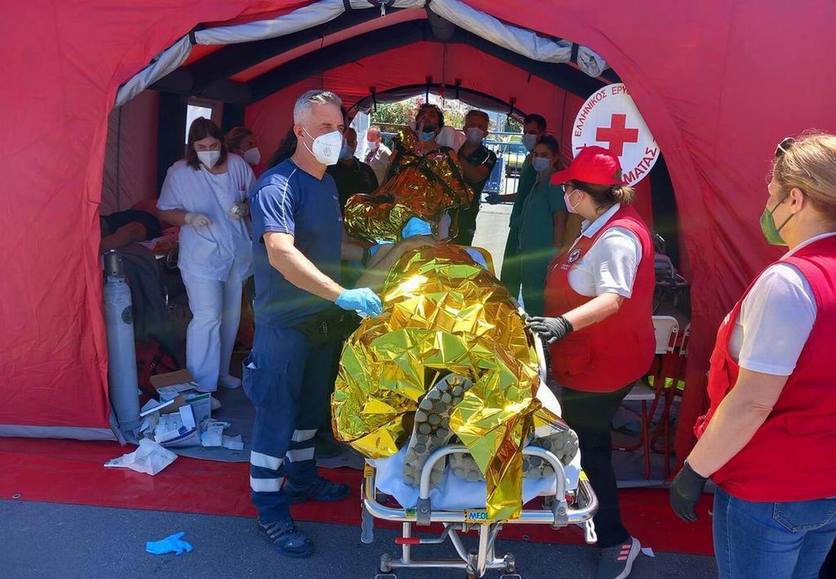 14 giugno 2023, porto di Kalamata (Grecia). Il personale medico presta soccorsi ai migranti sopravvissuti al naufragio del peschereccio partito dalle coste libiche. (Evangelos Bougiotis/Epa)
