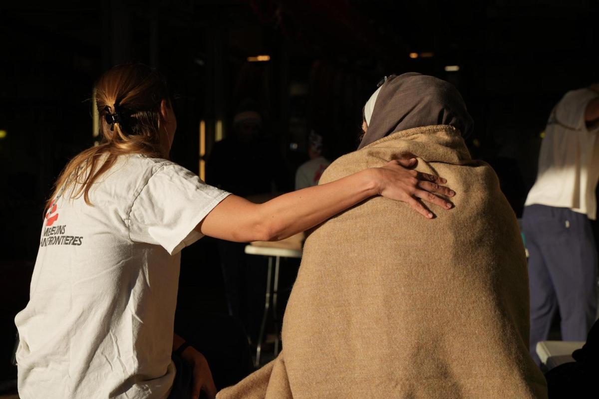 Genova, 26 gennaio 2024. Un'operatrice conforta una donna sbarcata dalla Geo Barents (Foto Medici Senza Frontiere/Ansa)