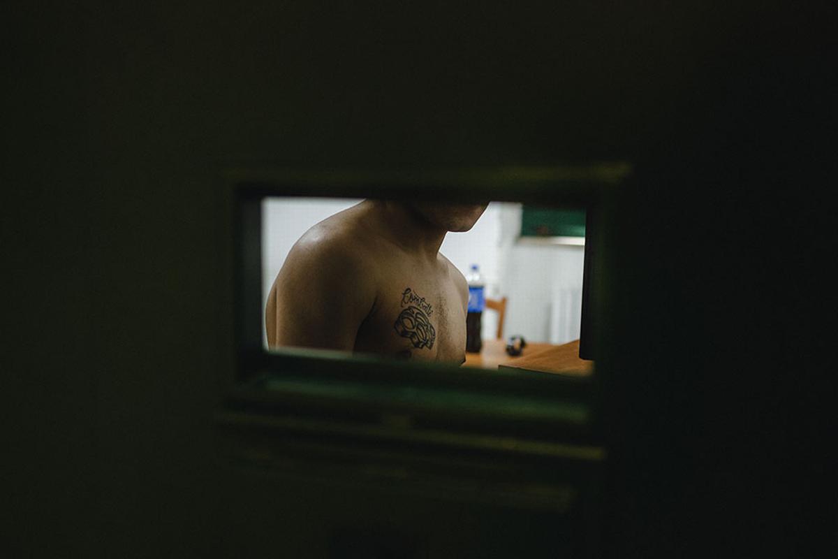 Nisida, maggio 2021. Un detenuto e il suo tatuaggio, un tirapugni con la parola "Combatti". Questa foto e le immagini che accompagnano il dossier "Tutti dentro" fanno parte del reportage Nisida – L'isola della gioventù sospesa, realizzato dal fotoreporter Yarin Trotta del Vecchio