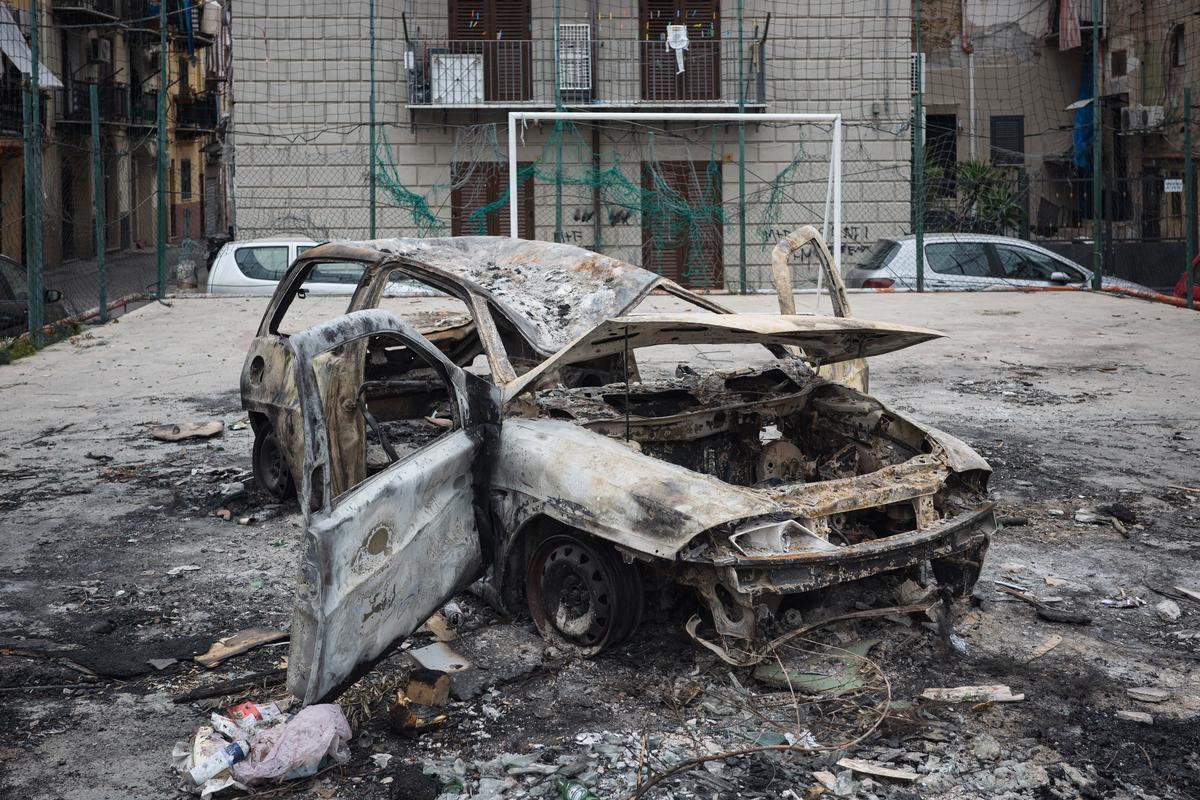 Palermo, quartiere Borgo Vecchio. Un'auto incendiata all'interno di un campo da calcetto, reso inagibile dal rogo. Foto di M. Panzarella
