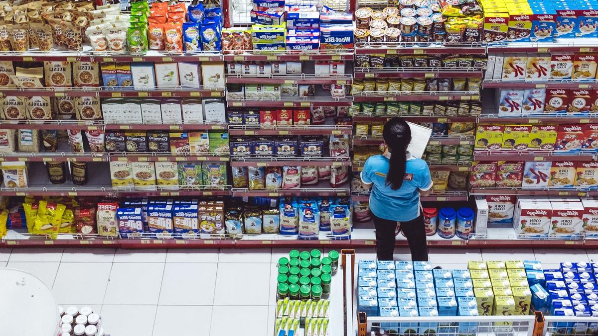 Un'impiegata al lavoro in un supermercato (foto Bernard Hermant/Unsplash)