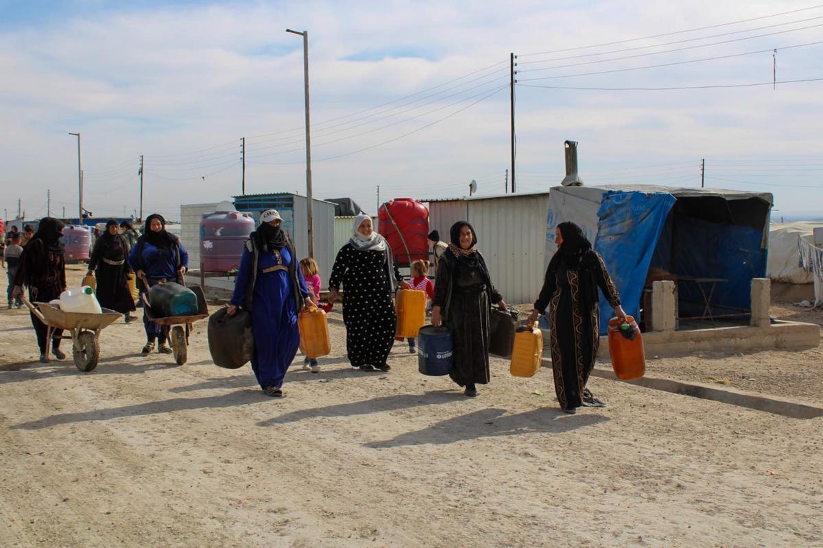 Donne si recano alle autobotti nel campo sfollati di Washokani, Al-Hasakah