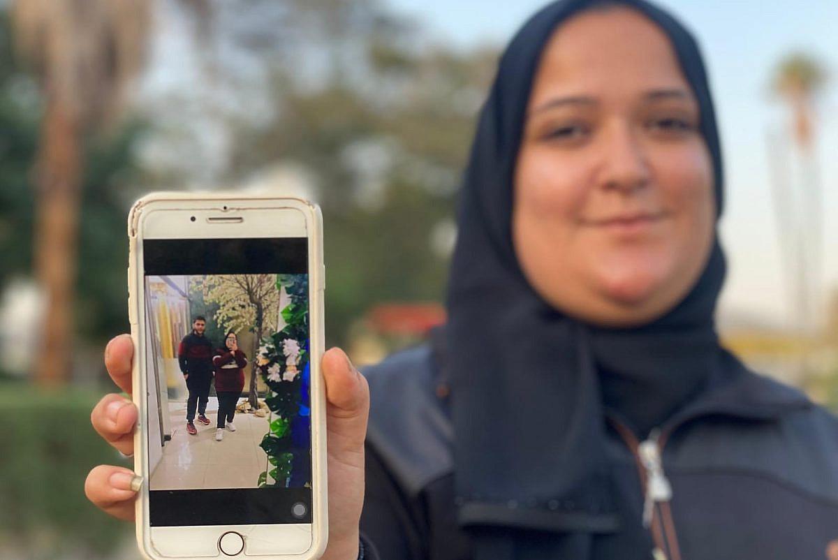 Laila Al-Helu mostra una foto sua e del fratello Shawqi, tra gli scomparsi di Gaza. Foto di Ahmed Ahmed/+972 Magazine