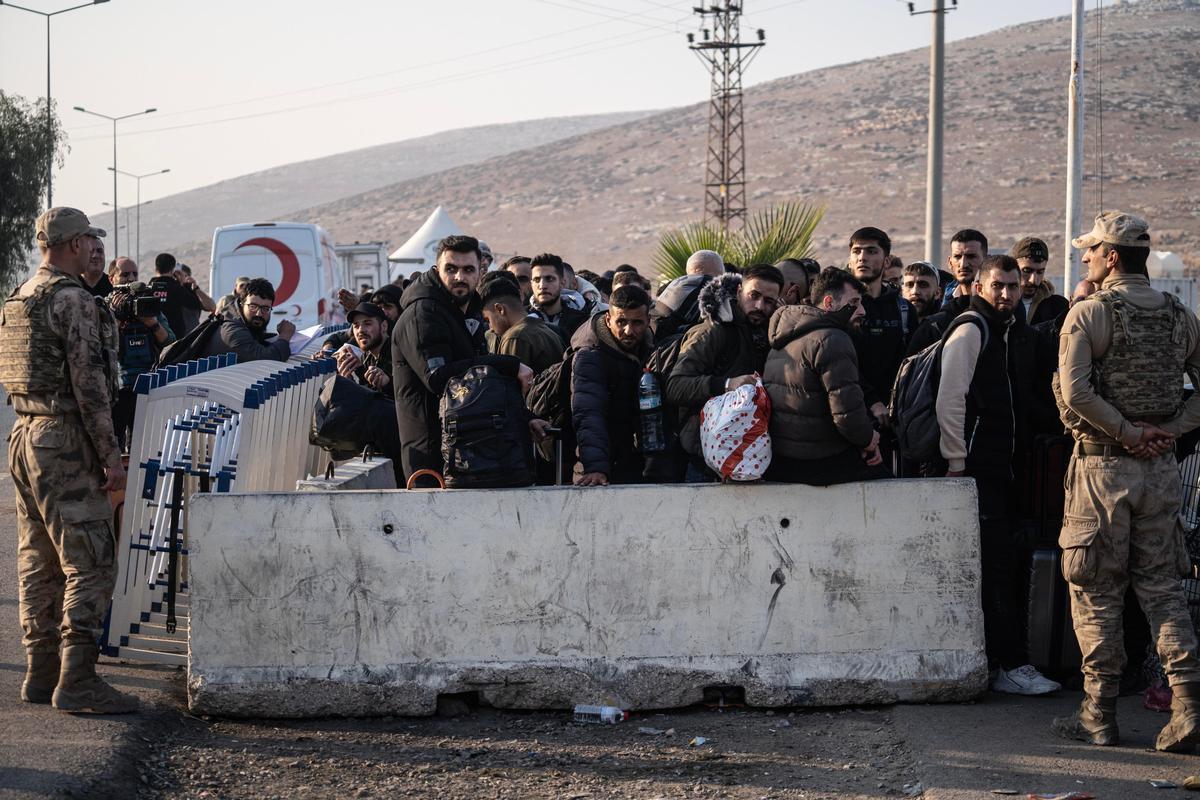 Confine turco-siriano, 10 dicembre 2024. Rifugiati in fila al valico di frontiera per rientrare in Siria dopo la caduta di Bashar al Assad. Foto di Kazim Kizil/Ansa