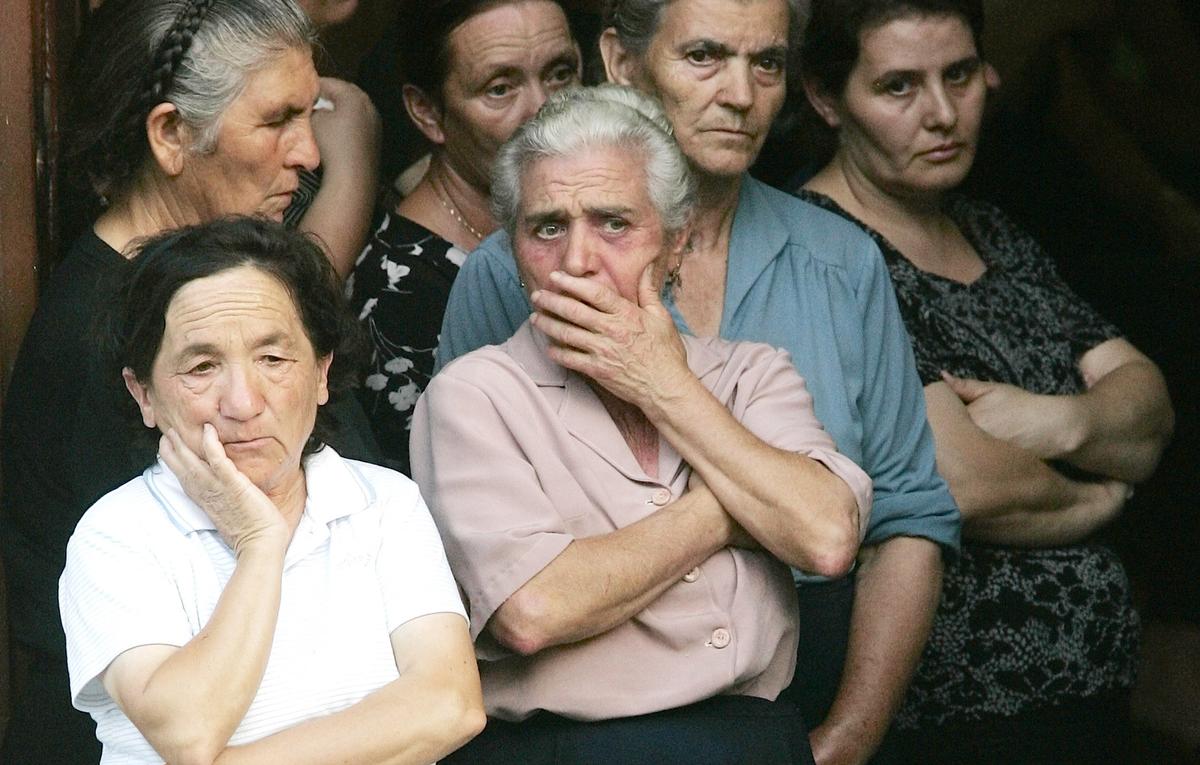 2007, San Luca. Un gruppo di donne aspettano in chiesa le bare di Francesco Giorgi, Sebastiano Strangio e Marco Marmo, tre delle vittime della strage di Duisburg (P. Cito/Ansa)