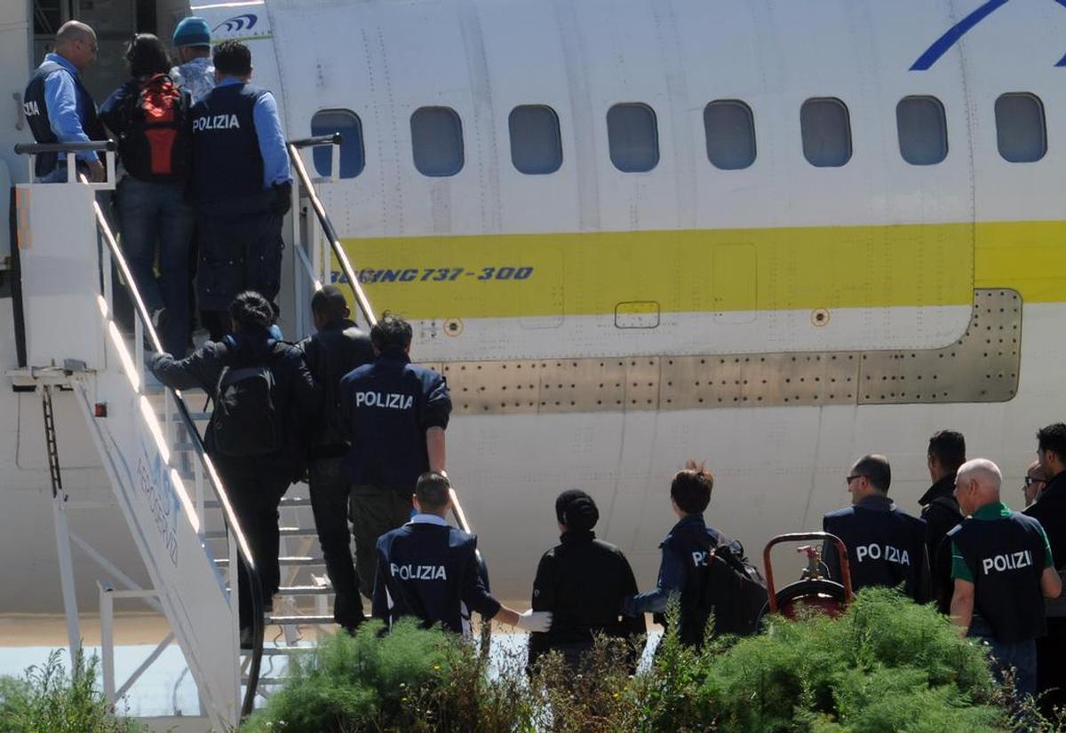14 aprile 2011, aeroporto di Lampedusa. Un volo per il rimpatrio di alcuni migranti tunisini (Carlo Ferraro/Ansa)