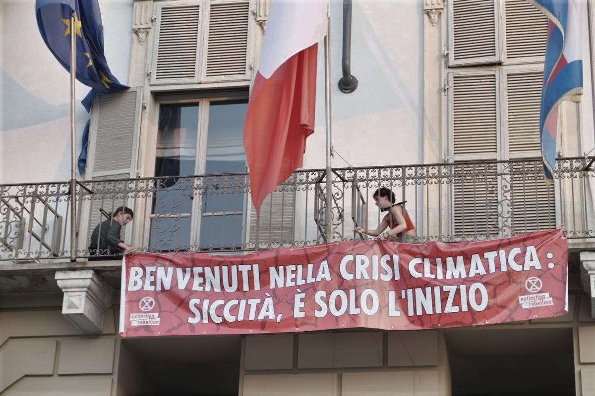 Due attiviste di Xr si incatenano davanti al balcone del palazzo della regione Piemonte, a Torino. Foto: Ufficio stampa Xr