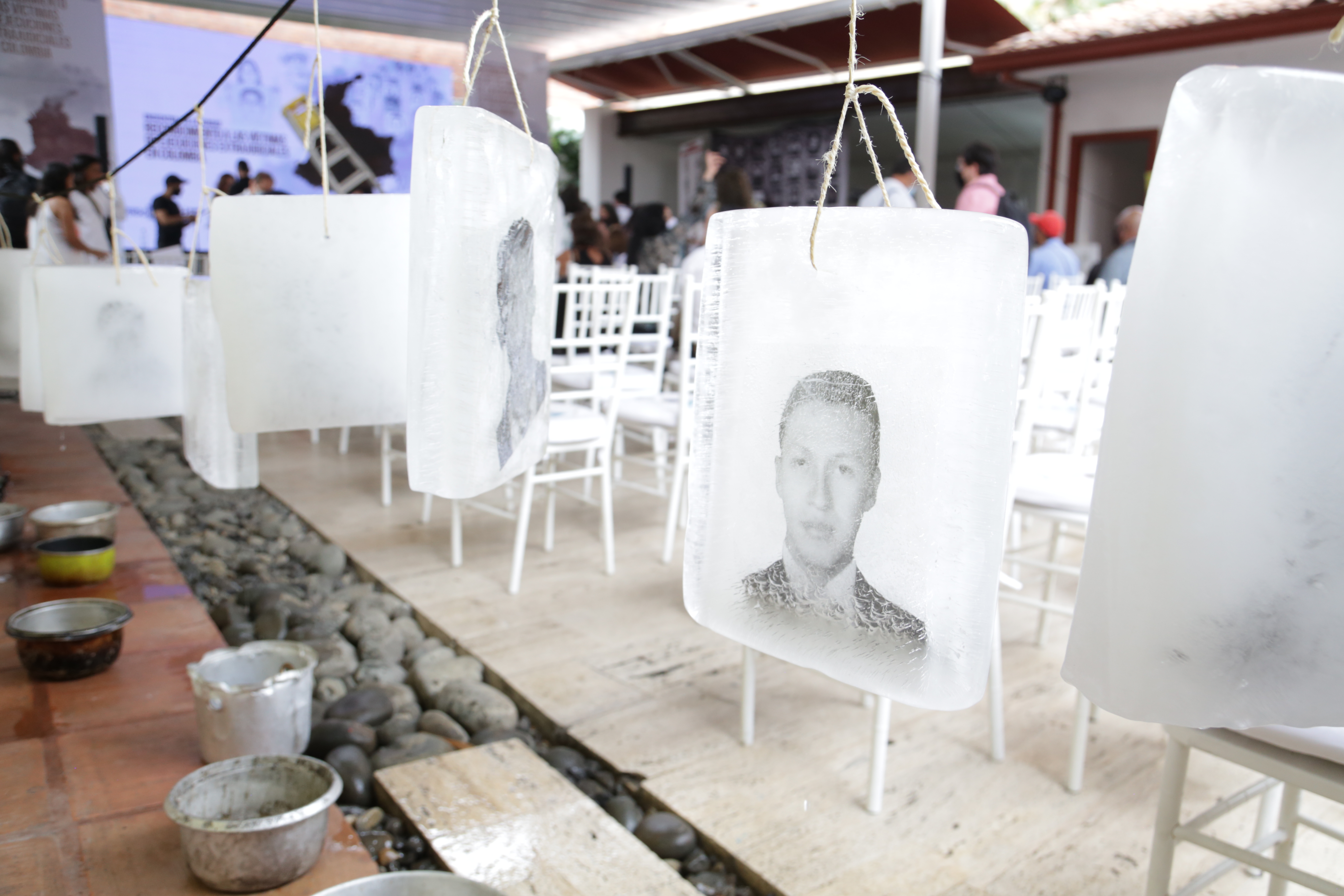 Cali (Colombia), 5 ottobre 2021. Le immagini di alcune vittime delle esecuzioni extragiudiziali compaiono con lo scioglimento del ghiaccio