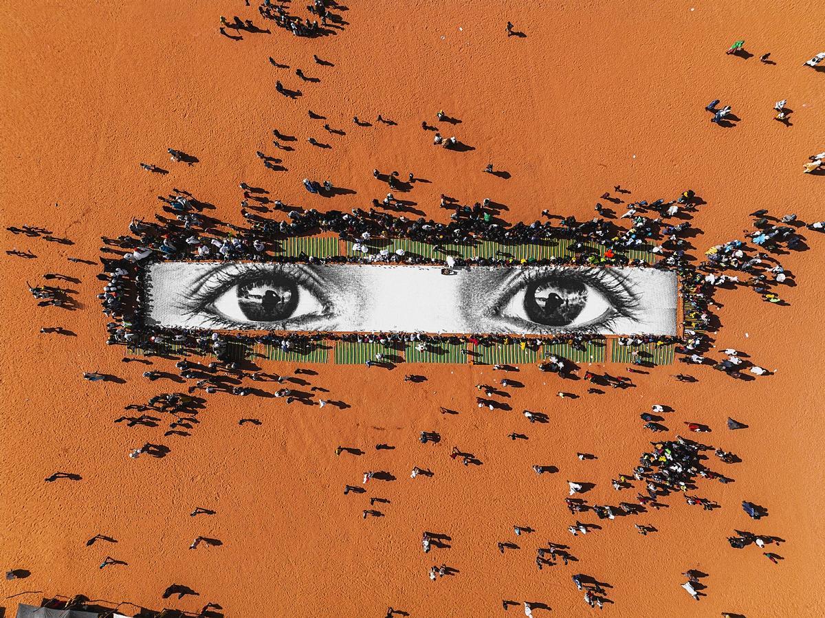 Il picnic intorno alla foto gigante degli occhi di un bimbo maliano, dal progetto Deplacées