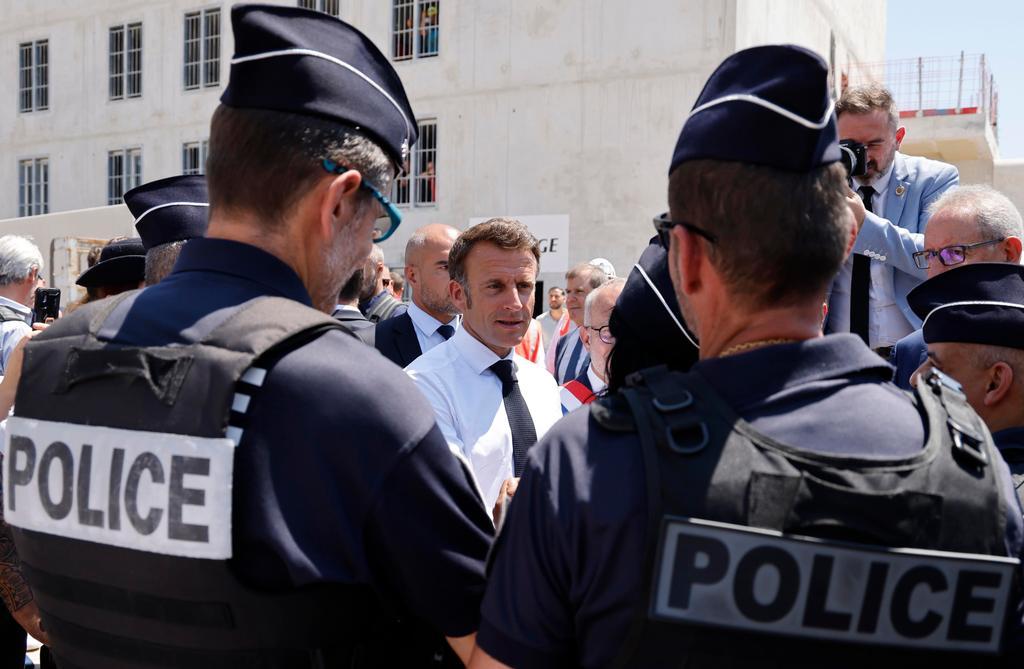 Marsiglia, 26 giugno 2023. Il presidente francese Emmanuel Macron parla con gli agenti di polizia durante la visita al cantiere del carcere di Baumettes (Ludovic Marin/Epa)