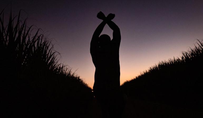 Batey Euskarduna, Repubblica Dominicana. dicembre 2024. Un ragazzo gioca saltando in una piantagione di canna da zucchero 