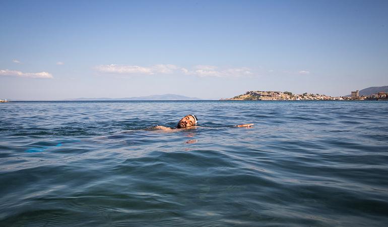 Lesbo (Grecia), estate 2024. Uno dei partecipanti al corso di nuoto di Yoga and Sport with Refugees si rilassa al largo dell'isola dopo una sessione di allenamento (Foto di Giacomo Sini)
