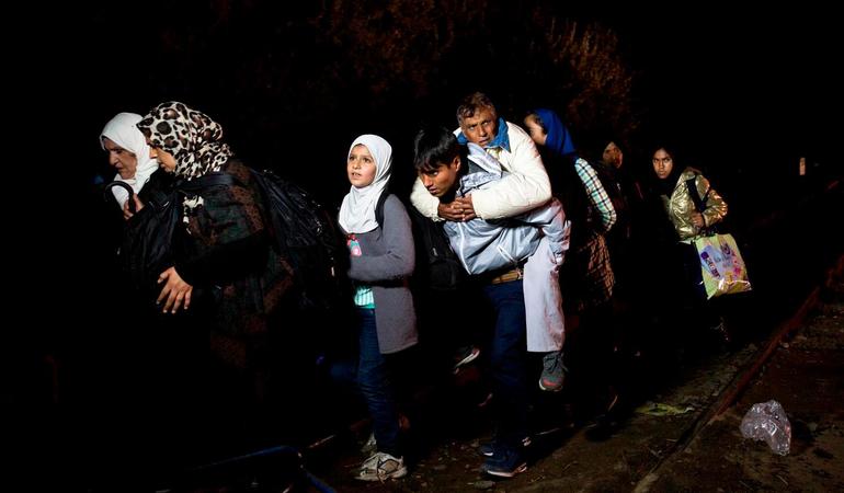 Un giovane afgano trasporta il padre sulle spalle lungo il confine serbo-ungherese, alle 23:50 del 14.09.15. A mezzanotte le autoritÃ  chiuderanno la frontiera. Foto di Valerio Muscella