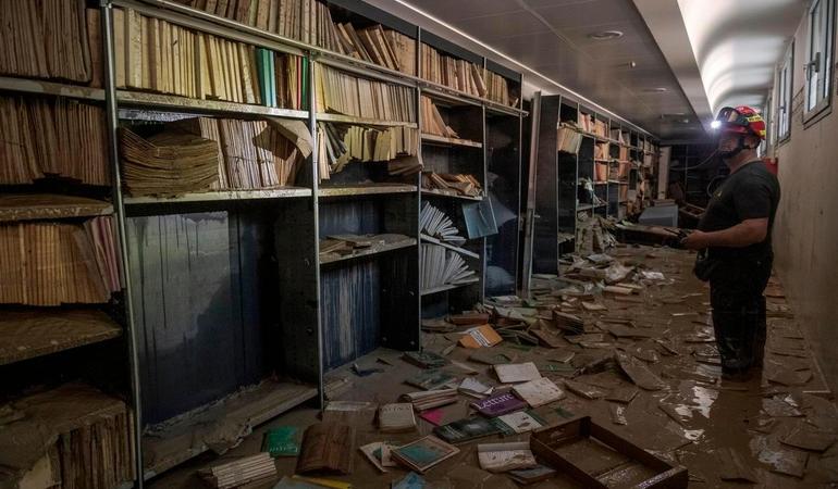 Forlì, 22 maggio 2023. Un vigile del fuoco ispeziona i locali della Biblioteca del Seminario pochi giorni dopo l'alluvione, con i libri che ancora galleggiano sull'acqua esondata dal fiume Montone/ Foto di Michele Lapini