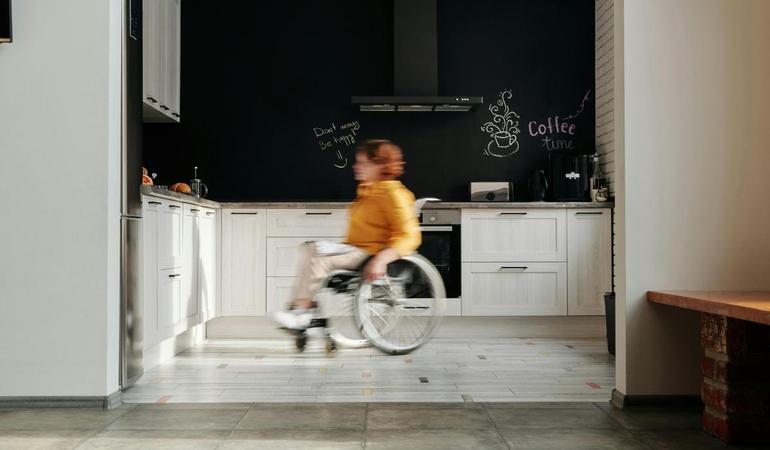 Una donna su una sedia a rotella in una casa accessibile (Foto di Marcus Aurelius da Pexels)