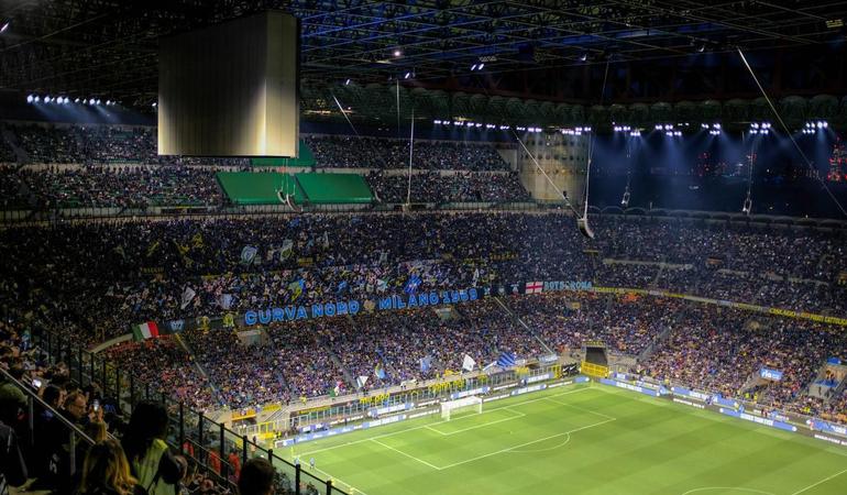 La curva nord dello stadio Giuseppe Meazza a Milano. Foto di <a href="https://unsplash.com/it/@zachr1992?utm_content=creditCopyText&utm_medium=referral&utm_source=unsplash">Zach Rowlandson</a> su <a href="https://unsplash.com/it/foto/uno-stadio-pieno-di-gente-che-guarda-una-partita-di-calcio-yQIsrc3VnM8?utm_content=creditCopyText&utm_medium=referral&utm_source=unsplash">Unsplash</a> 