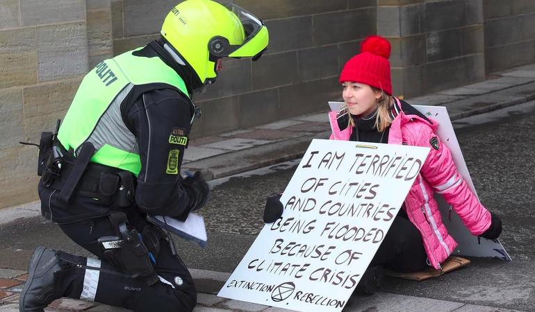 Una ragazza protesta durante una manifestazione. Sul cartello: "Sono terrorizzata dagli allagamenti nelle città  e nei Paesi causati dalla crisi climatica" Crediti: facebook/Extinction rebellion