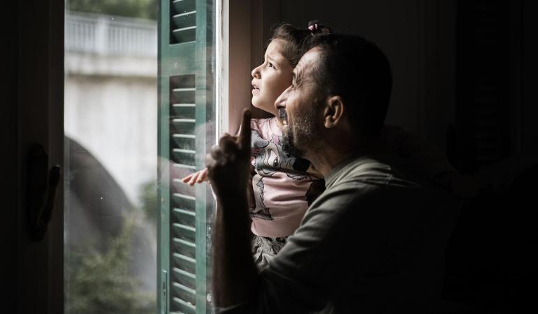 Rossiglione, 26 settembre 2025. Mohammed tiene in braccio Risal, preoccupata dal rumore di un elicottero che sta sorvolando la loro nuova casa. Foto di M. Panzarella