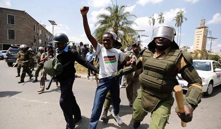 Francis Sakwa, attivista keniano, tra due agenti delle forze dell'ordine