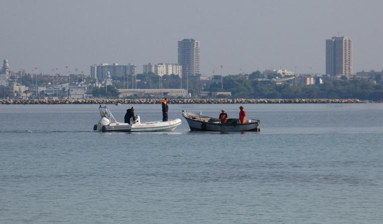 Due militari della guardia costiera controllano dei pescatori di frodo di cetrioli di mare (Guardia costiera)