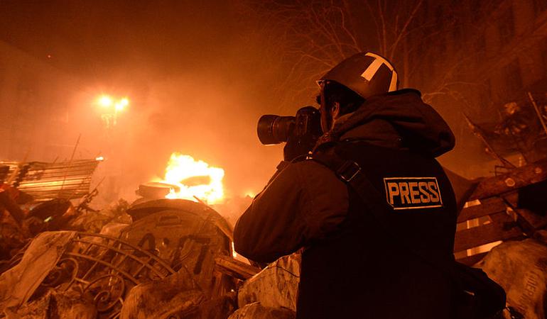 Un giornalista documenta gli scontri tra cittadini e polizia a Kyiv, nel 2014 