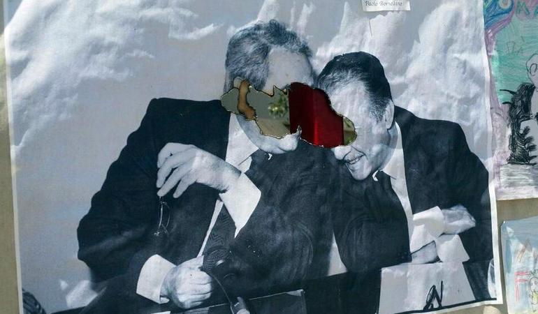 Palermo, 11 luglio 2017. Un manifesto con la foto di Falcone e Borsellino dato alle fiamme (Ansa)