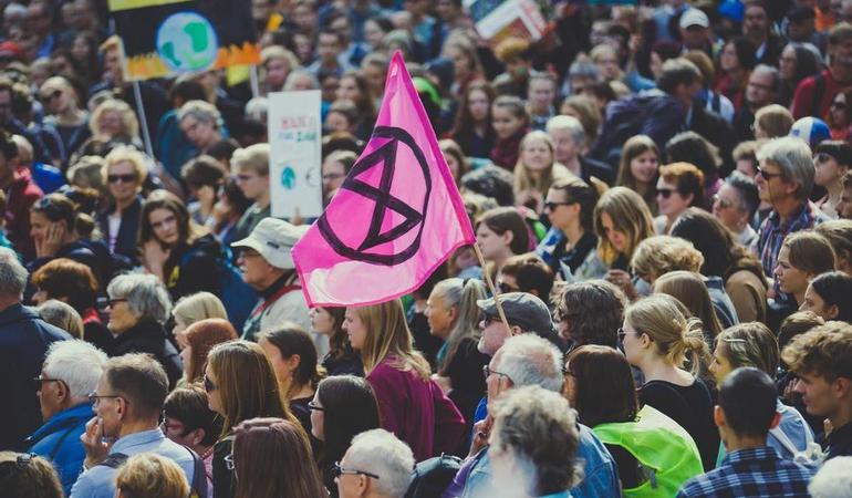 La bandiera di Xr durante una protesta. Credits: Spiske/Unsplash
