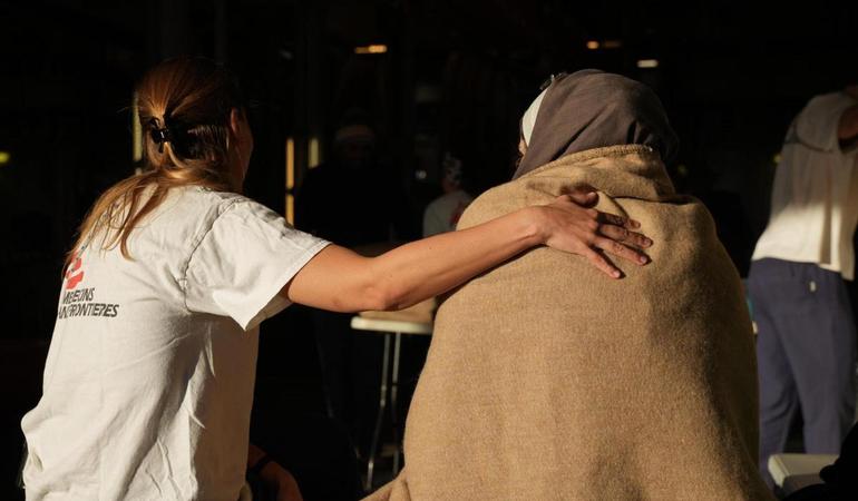 Genova, 26 gennaio 2024. Un'operatrice conforta una donna sbarcata dalla Geo Barents (Foto Medici Senza Frontiere/Ansa)