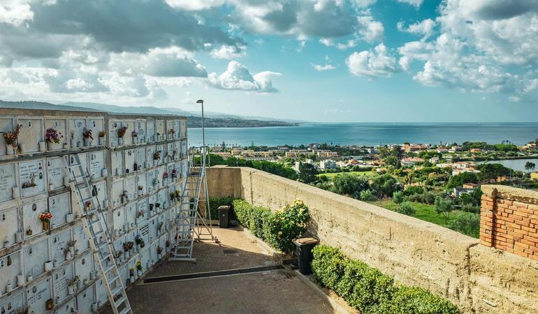 Messina, settembre 2024. Il cimitero di Granatari, a Torre Faro, è l'unico terreno non interessato dagli espropri nel cantiere nord. Probabilmente non sarà accessibile durante i lavori, mentre tutte le abitazioni intorno dovrebbero essere demolite per fare spazio al pilone del ponte (Foto di Paolo Valenti)