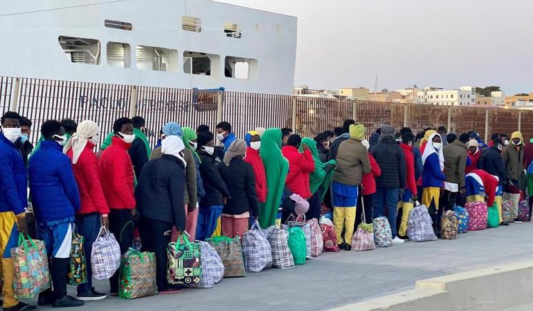 Lampedusa, 15 marzo 2024. Migranti in fila per essere trasferiti a Porto Empedocle. Foto di Elio Desiderio/Ansa