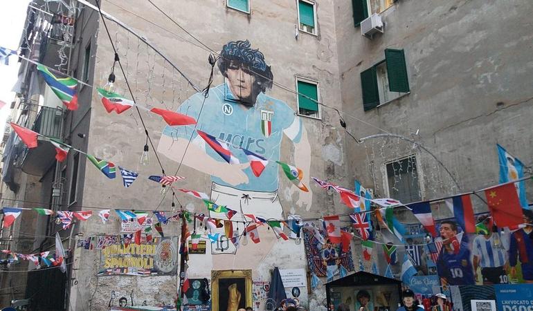 Napoli, il murales di Diego Armando Maradona nei quartieri spagnoli è diventato una metà turistica dove vengono venduti souvenir e gadget legati al campione