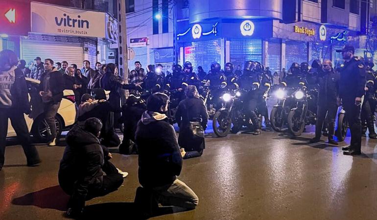 Teheran, gennaio 2026. Giovani manifestanti in ginocchio di fronte agli agenti di sicurezza del regime in motocicletta (Telegram/Mamlekate)