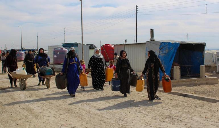 Donne si recano alle autobotti nel campo sfollati di Washokani, Al-Hasakah