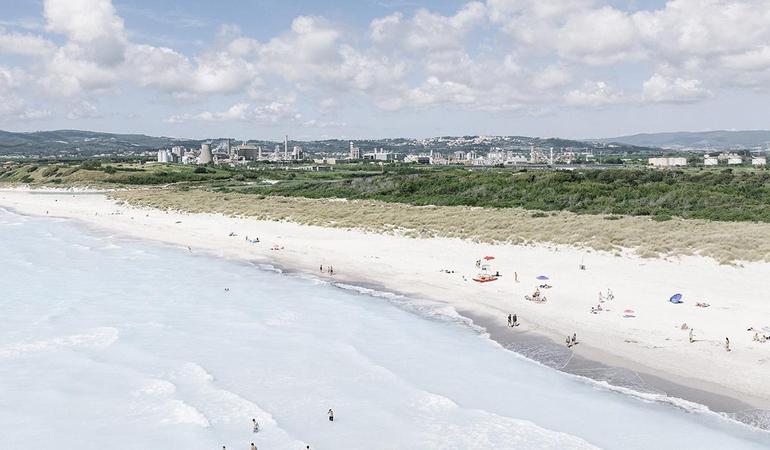 Giugno 2026. Spiagge Bianche, Rosignano Solvay. Veduta aerea della costa bianca e dello stabilimento Solvay dietro le dune. Nonostante il punto di scarico sulla spiaggia e i divieti di balneazione e transito entro 100 metri, residenti e turisti continuano a frequentare la spiaggia © Melanie Wenger/Inland