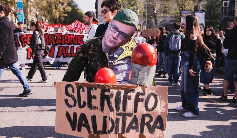 Torino, aprile 2025. Un manifestante indossa la maschera del ministro Valditara 