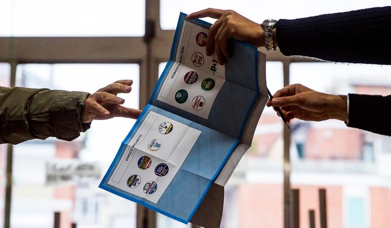 Un elettore prende la scheda elettorale per il ballottaggio delle amministrative a Roma (Carconi/Ansa)