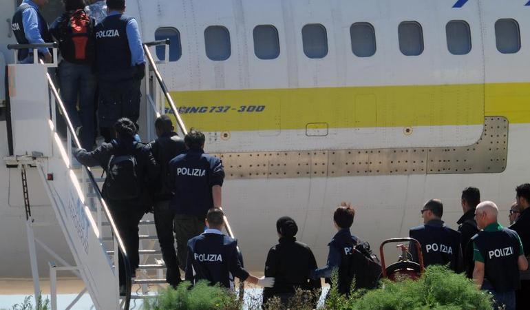 14 aprile 2011, aeroporto di Lampedusa. Un volo per il rimpatrio di alcuni migranti tunisini (Carlo Ferraro/Ansa)