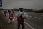 Taras, originario di Ternopil, tiene in braccio sua figlia e cammina con la propria famiglia nei pressi del passaggio di frontiera di Budomierz, Polonia