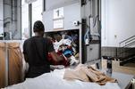 Rho (Milano). Un operatore smista gli abiti arrivati al Textile hub. Dopo l'igienizzazione, saranno destinati alla vendita al dettaglio nei negozi della cooperativa Vesti solidale o ad aziende che comprano all'ingrosso